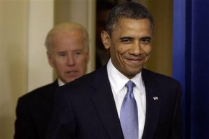 El presidente Barack Obama llega satisfecho a una reunión con periodistas en la Casa Blanca la noche del martes 1 de enero de 2013. Acompañado del vicepresidente Joe Biden, atrás, Obama anunció que promulgará la iniciativa de ley que poco antes terminó de aprobar el Congreso para evitar el llamado "abismo fiscal". (Foto AP/Charles Dharapak)