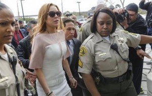 Lindsay Lohan llega con su abogado Mark Heller a la Corte Superior de Los Angeles el lunes 18 de marzo de 2013. Lohan está acusada de tres cargos menores tras un choque en California y podría volver a prisión por violar su libertad condicional. (Foto AP/Damian Dovarganes)