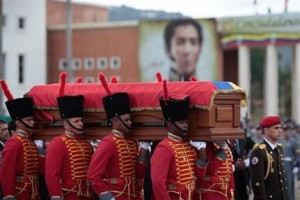 Soldados transportan el féretro del finado presidente Hugo Chávez al inicio de una procesión de la academia militar hasta el museo militar, donde reposarán los restos del mandatario en Caracas, Venezuela, el viernes 15 de marzo de 2013. Al fondo, un retrato del prócer independentista Simón Bolívar. (AP Foto/Oficina de Prensa de Miraflores)