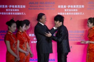 El cantante español Julio Iglesias, centro izquierda, abraza al pianista chino Lang Lang durante una ceremonia en la que Iglesias recibió el récord mundial Guinness al artista latino masculino con mayores ventas de discos en el mundo en Beijing, China, el lunes 1 de abril de 2013. (Foto AP/Alexander F. Yuan)
