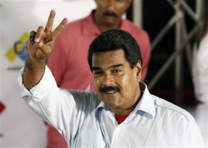 El presidente encargado de Venezuela y candidato oficialista Nicolás Maduro hace el signo de la victoria tras sufragar en un centro de votación en Caracas, Venezuela, el domingo 14 de abril de 2013. (AP foto/Ariana Cubillos)