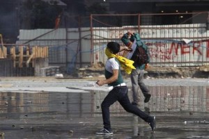 Manifestantes lanzan piedras durante los enfrentamientos con la policía antimotines en la plaza Taksim, en Estambul, Turquía, el martes 11 de junio de 2013. (Foto AP/Kostas Tsironis)
