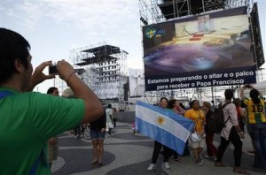 Peregrinos argentinos se toman fotos al frente de una de las pantallas gigantes colocadas a lo largo de la playa de Copacabana para transmitir las actividades del Papa Francisco que llega el lunes para encabezar la Jornada Mundial de la Juventud. Río de Janeiro , el domingo 22 de julio de 2013. (AP Photo/Jorge Saenz).