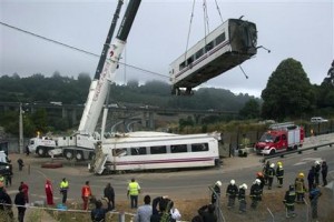 Una grúa levanta el jueves 25 de julio los vagones de un tren de pasajeros que se descarriló el día anterior en Santiago de Compostela, España. Al menos 77 personas perdieron la vida y 141 quedaron heridas, según las autoridades. (AP Foto/ Lalo Villar)