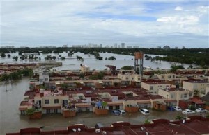 Vecindarios enteros inundados y personas paradas en los techos de las casas después de que la tormenta tropical Manuel golpeara el famoso Puerto turístico de Acapulco, México, el martes 17 de septiembre de 2013.  Cientos de turistas han resultado damnificados a la vez y hoy buscan los medios para salir del famoso balneario. (AP/ Bernandino Hernandez)