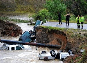 Autoridades investigan el colpaso de una parte de la vía en la Carretera 287 y Dillon en la frontera Broomfield/Lafayette en Colorado, en que tres vehículos cayeron al agua después de una inundación repentina, el jueves 12 de septiembre de 2013. (Foto AP/Daily Camera, Cliff Grassmick)