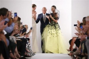 El diseñador Oscar de la Renta, centro, recibe al aplauso del público tras el desfile de su colección primavera 2014 en la Semana de la Moda de Nueva York en una fotografía del 10 de septiembre de 2013. (Foto AP/John Minchillo)