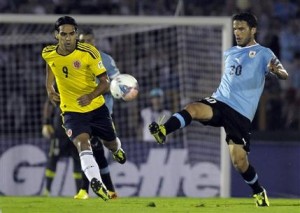 El colombiano Radamel Falcao, izquierda, observa cuando el uruguayo Álvaro González despeja un balón en el partido por las eliminatorias del Mundial en Montevideo, Uruguay, el martes 10 de septiembre de 2013. (AP Foto/Matilde Campodonico)