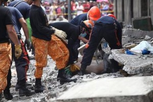 Personal de emergencia rescata a un hombre entre los escombros de un edificio destrozado en el puerto pesquero de Pasil, Cebú, en la zona central de Filipinas, el martes 15 de octubre de de 2013. Un terremoto de magnitud 7,2 grados provocó el derrumbe de edificios, dañó carreteras y derribó el camapanario de la iglesia más antigua del país el martes por la mañana. (Foto AP/Chester Baldicantos)