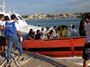 Un bote del guardacostas italiano traslada a inmigrantes rescatados del mar al puerto de Lampedusa, el jueves 3 de octubre de 2013. (Foto AP/Nino Randazzo,Servicio de Cuidados de Salud, HO)