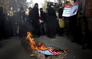 Manifestantes iraníes queman una bandera estadounidense durante una protesta anual contra Estados Unidos en Teherán, el lunes 4 de noviembre de 2013. (Foto AP/Ebrahim Noroozi)