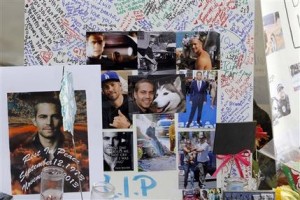 Fotografías y mensajes de admiradores de Paul Walker forman parte de un homenaje improvisado en el lugar donde el actor y un amigo murieron el sábado en un accidente automovilístico, el lunes 2 de diciembre del 2013 en Valencia, California. (AP Foto/Nick Ut)