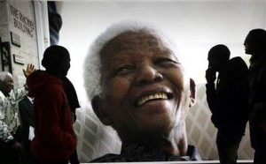 Fotografía de archivo del 27 de junio de 2013 de varias personas admirando una exposición fotográfica en honor del ex presidente sudafricano Nelson Mandela en el Centro Cívico de Cape Town, Sudáfrica. (Foto AP/Archivo)