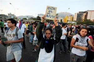 Manifestación en Caracas el jueves 13 de febrero de 2014 contra la violenta represión de los estudiantes el día anterior. El gobierno y la oposición se culparon mutuamente por los choques de la víspera, cuando partidarios del gobierno que se desplazaban en motos dispararon contra un grupo de manifestantes que habían chocado con la policía. (Foto AP/Fernando Llano)