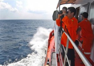 Un miembro de la Agencia Nacional de Búsqueda y Rescate de Indonesia usa binoculares para revisar el horizonte durante una operación de búsqueda del Boeing 777 de Malysia Airlines en el Estrecho de Malaca cerca de la isla de Sumatra, Indonesia, el miércoles 12 de marzo de 2014. (Foto AP/Heri Juanda) 