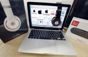 Productos de Beats Audio se exhiben junto a una computadora portátil de Apple en una tienda Best Buy en Boston. Apple anunció el miércoles 28 de mayo del 2014 que está adquiriendo Beats Electronics por 3.000 millones de dólares. (AP Foto/Michael Dwyer, Archivo)