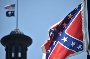 La bandera confederada se ha convertido en un símbolo que ha atraído  enojo por la matanza de nueve hombres y mujeres afro americanos en la iglesia Episcopal Metodista Africana Emanuel el 18 de junio. El acusado por la matanza, el joven blanco de 21 años Dylann Roof, apareció posando con el emblema en un sitio web.