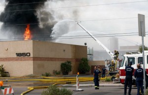 Personal del cuerpo de bomberos de Phoenix, tratan de apagar las llamas de un intenso incendio que se produjo  en una compañía de reciclaje de solventes al sur del centro de Phoenix, Arizona, el miércoles 9 de septiembre de 2015. (Foto de Rob Schumacher/The Arizona Republic vía AP) 