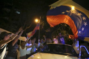 Ondeando banderas con los colores venezolanos, lanzando fuegos artificiales y tocando la bocina de sus autos, muchos militantes de la oposición festejaban mientras otros se abrazaban y besaban en el comando de la MUD, al este de Caracas. Diciembre 7, 2015. REUTERS/Nacho Doce