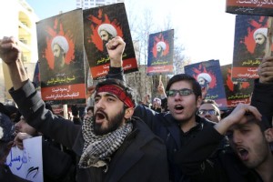 Manifestantes iraníes entonan cánticos durante una protesta por la ejecución de Sheikh Nimr al-Nimr, un prominente clérigo chiita de oposición en Arabia Saudí, quien aparece en los carteles, frente a la embajada saudí en Teherán, el domingo 3 de enero de 2016.