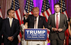 El candidato republicano Donald Trump de pie, en la mitad de su jefe de campaña Corey Lewandowski (I) y su hijo Eric (D) mientras se pronunciaba sobre los resultados en las primarias en Florida, Ohio, North Carolina, Illinois y Missouri durante una conferencia con los medios en su mansión de Mar-A-Lago en Palm Beach, Florida. Marzo 15, 2016. REUTERS/Joe Skipper