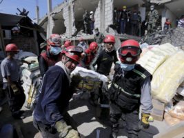 Rescue team members carry the body of a victim at a collapsed building after an earthquake struck off the Pacific coast, in Pedernales, Ecuador. REUTERS/Henry Romero