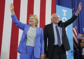 Los candidatos presidenciales demócratas Bernie Sanders y Hillary Clinton saludan durante un acto de campaña en Portsmouth, Nuevo Hampshire, Estados Unidos. 12 de julio de 2016. El senador Bernie Sanders respaldó el martes a su ex rival en la carrera por la nominación presidencial demócrata Hillary Clinton, en una muestra de unidad del partido, al decir que es la mejor candidata para resolver los problemas del país y para ganarle al republicano Donald Trump en la elección de noviembre. REUTERS/Brian Snyder
