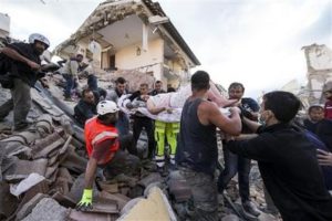 Una mujer es sacada a hombros en una camilla de debajo de los escombros tras el terremoto que sacudió Amatrice, una localidad en el centro de Italia, el 24 de agosto de 2016. (Massimo Percossi/ANSA via AP)
