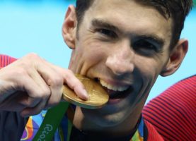 Michael Phelps poses with his gold medal. REUTERS/Marcos Brindicci