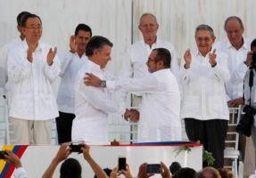 Colombian President Juan Manuel Santos (L) and Marxist rebel leader Timochenko shake hands after signing an accord ending a half-century war that killed a quarter of a million people, in Cartagena