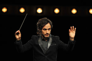 Con su estreno en el 2014, "Mozart in the Jungle" presentó a un joven director audaz y carismático que queda a cargo de la Orquesta Sinfónica de Nueva York.  Al comenzar la tercera temporada de esta serie de comedia de Amazon Prime, cuyos 10 episodios pueden verse a partir del viernes, la orquesta está en huelga, lo que libra al maestro Rodrigo de dirigir el regreso a los escenarios de una emblemática diva de la ópera en Venecia. En ese exótico escenario, las voces se elevan y las chispas vuelan.